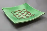 Merilyn Wiseman, Large slab square platter, raised on four feet, decorated with a central panel in orange on a green ground