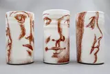 Terry Stringer & John Dawson, Three small cylinder vases, glazed porcelain potted by John Dawson and decorated by Terry Stringer with brown decal face designs