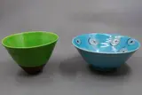 Two small bowls by Warren Tippett, one with circle and dots abstract decoration on a bright blue ground, the other with green glaze (one restored), sold Jun 2026