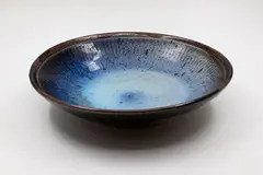 Stoneware bowl by Len Castle, with light blue and purple glaze over tenmoku, sold Feb 2026
