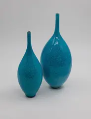 Peter Collis, Two slender vases, with spire necks and bright turquoise crackle glaze (good repair to one neck)