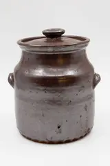 Lidded crock by Barry Brickell, persimmon glazed stoneware of barrel form with cup handles, sold Feb 2026