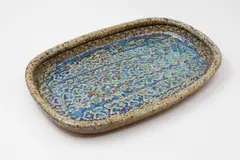 Barry Brickell, Rectangular platter, stoneware with mottled oatmeal glaze giving to a pool of blue glaze to the centre with impressed decoration (flake chip and hairline crack to base)