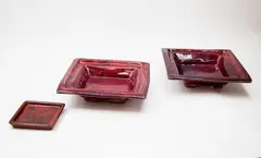 Doreen Blumhardt, Pair of square platters, stoneware with flambé glaze with red and purple tones (one restored); together with a matching small pin dish by an unidentified potter