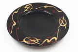 Peter Collis, Large wall plate, porcelain with shiny black glaze, the wide straight rim decorated with gold and red gestural design