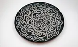 Māori inspired display dish by Sang Sool Shim & Keum Sun Lee, terracotta with incised and painted black and white Māori inspired design, sold May 2025