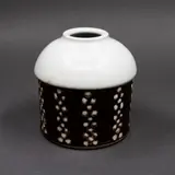 Graeme Storm, Domed cylinder vase, porcelain, the body decorated with bands of white dots on a dark brown ground, very pale celadon glaze to the domed top