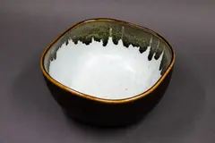 Squared circular bowl by Graeme Storm, stoneware with poured dark iron glaze to the rim and exterior, pale blue glaze to the interior, sold May 2025