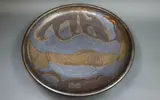 Graeme Storm, Stoneware charger, with manganese glaze with dark gloss gold highlights