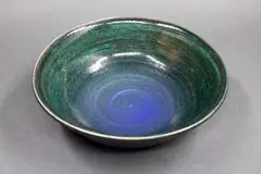 Stoneware bowl by Graeme Storm, with gloss dark green glaze over matt blue barium glaze, offered May 2025