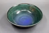 Stoneware bowl by Graeme Storm, with gloss dark green glaze over matt blue barium glaze, offered May 2025