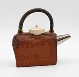 Peter Lange, 'Broken Brick' teapot, the earthenware body shaped as a broken brick, the handle as an iron rod and the lid as a bath plug (firing cracks)