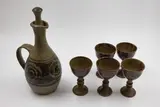 Adrian Cotter, Wine jug and five goblets, stoneware with ash glaze, decorated with a wax resist spiral design
