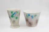 Set of two hand-painted vases by Crown Lynn, with primroses on a log decoration, offered May 2025