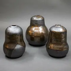 Set of three gourd vases by Graeme Storm, stoneware with manganese glaze with gold highlights, offered May 2025