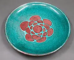 Stoneware dish by Graeme Storm, decorated with a copper red patterned centre on blue green ground, offered May 2025