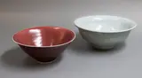 Graeme Storm, Two Chinese style bowls, comprising a porcelain bowl with rich copper red glaze, and a stoneware bowl with pale celadon glaze