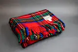 Clan travel rug by Kaiapoi Petone Group Textiles, with a Royal Stewart tartan pattern in bright red, blue, green, yellow, black and white, offered May 2025