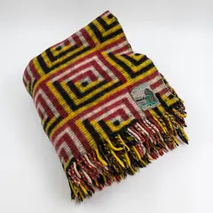 Early Manatunga travel rug by Roslyn Dunedin textiles, with a tukutuku panel pattern in magenta, yellow, black, and white (in washed condition), sold May 2025