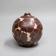 Orb vase by Graeme Storm, decorated with sgraffito cut floral design in dark red on a white background, sold Sep 2024