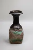Graeme Storm, Trumpet vase, stoneware with manganese glaze to the neck, the body with carved ribbed decoration with copper red and cobalt blue pigment