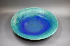 Wall charger by Graeme Storm, stoneware with mottled blue and green barium glaze, fitted with hanging wire, offered Sep 2024
