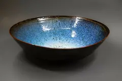 Large table bowl by Len Castle, stoneware with jun glaze over tenmoku (glaze cracks), sold Sep 2024