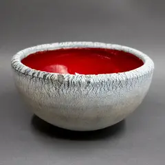 Hemispherical bowl by Len Castle, stoneware, with red lava glaze interior and oxide textured exterior, sold Sep 2024