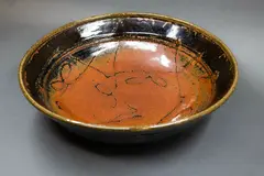 Large table bowl by Len Castle, stoneware with tenmoku glaze and wax resist gestural decoration to the centre, offered Sep 2024