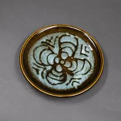 Small stoneware dish by Graeme Storm, decorated with wax resist radiating design on pale blue and light brown glaze, sold Sep 2024