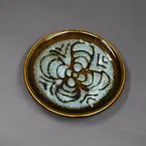 Graeme Storm, Small stoneware dish, decorated with wax resist radiating design on pale blue and light brown glaze
