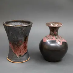 Two small stoneware vases by Graeme Storm, with manganese glaze with copper red highlights, offered Sep 2024