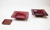 Doreen Blumhardt, Pair of square platters, stoneware with flambé glaze with red and purple tones (one restored); together with a matching small pin dish by an unidentified potter