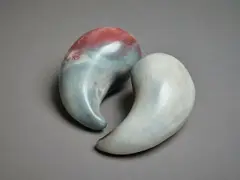 Two small raku fired sculptures by Potter Unknown, of yin and yang shape, with polished surface, sold Sep 2024