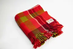 Kaiapoi Textiles Ltd, Huia travel Rug, with a tartan design in bright and dark red, olive green and white