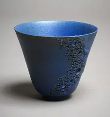 Potter Unknown, Small flaring vase, with blue matt glaze and pierced decoration