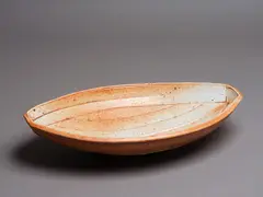 Peter Alger, Large oval platter, shino glazed stoneware, made in the style of the hull of a clinker-built boat, originally described by the potter as a 'lapstrake skiff form'