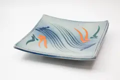 Large slab square platter by Merilyn Wiseman, raised on four lug feet, with Mashiko-rock abstract decoration in blue, green and orange on a soft blue ground, offered May 2024