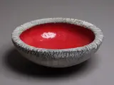Red Lava Bowl by Len Castle, earthenware with deep red lava glazed interior and grey textured exterior (small chip), sold May 2024