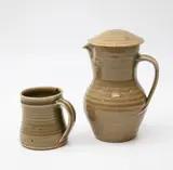 St Ives Pottery, Lidded jug and mug, with celadon glaze, impressed oak leaf design to the lid
