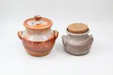 Andrew van der Putten, Two stoneware handled jars, the first with ceramic lid and crackle shino glaze with reddish tones, the second with a light toned shino glaze and cork stopper (one with hairline)
