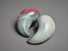Two small raku fired sculptures by Potter Unknown, of yin and yang shape, with polished surface, offered May 2024