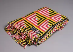 U.E.B. Textiles Ltd, Manatunga travel rug, with a tukutuku panel pattern in magenta, yellow, black, and white