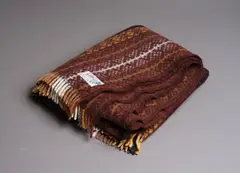 Onehunga Woollen Mills, Te Ariki travel rug, with a tukutuku panel pattern in mustard yellow, light and dark browns, black, white and with a fine green line woven throughout