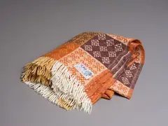 Onehunga Woollen Mills, Te Ariki travel rug, decorated with a tukutuku panel pattern in different shades of brown and white