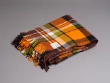 Kaiapoi, Early Huia travel rug, in bright orange, brown, green, black and white tartan design
