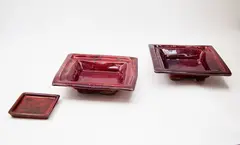 Doreen Blumhardt, Pair of square platters, stoneware with flambé glaze with red and purple tones (one restored); together with a matching small pin dish by an unidentified potter