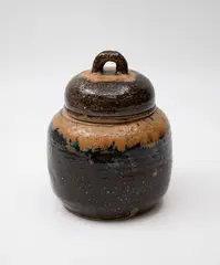 Lidded jar by Barry Brickell, with salt and ash glaze, a tan coloured band around the shoulders, loop finial to the lid, sold Feb 2024