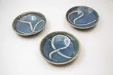 Barry Brickell, Set of three bowls, stoneware with wax resist gestural decoration on a pale blue ground