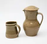 St Ives Pottery, Lidded jug and mug, with celadon glaze, impressed oak leaf design to the lid